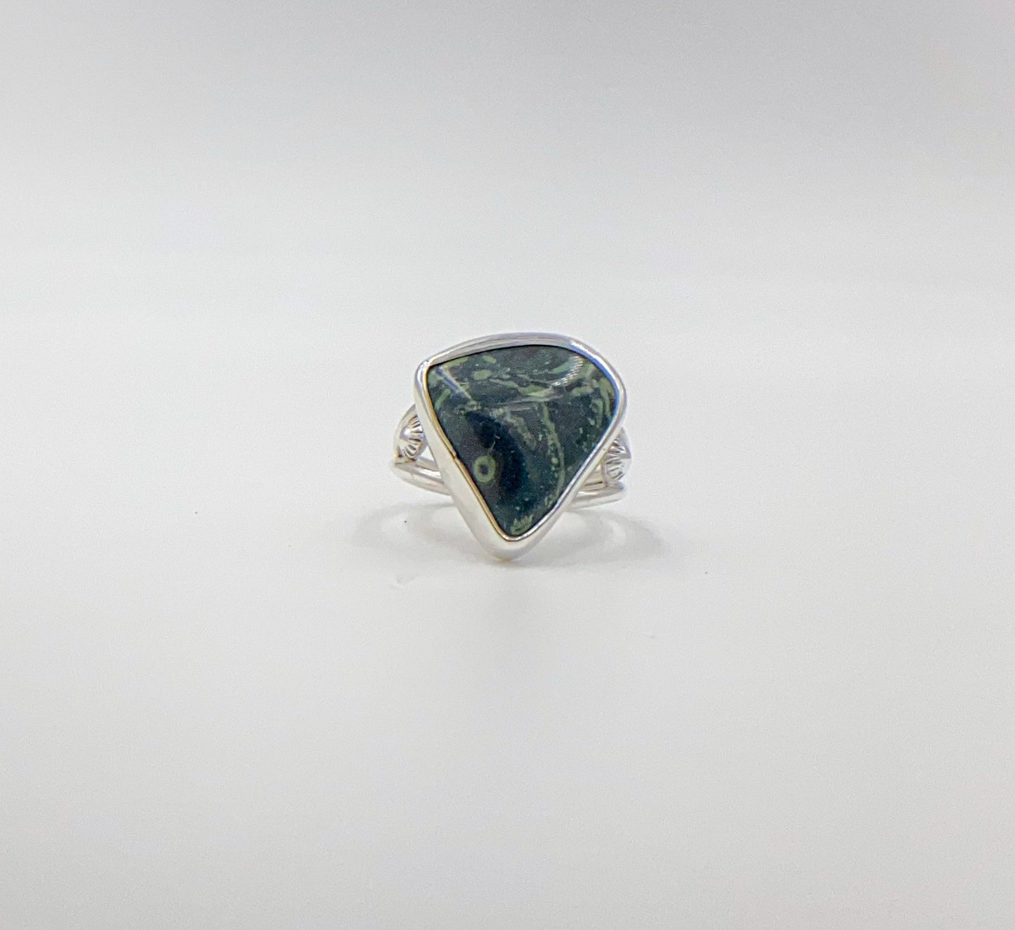 Malachite triangle cabachon mounted an a round profile band. Pieces of ornate granulation surround on the left and right.Split shank band.