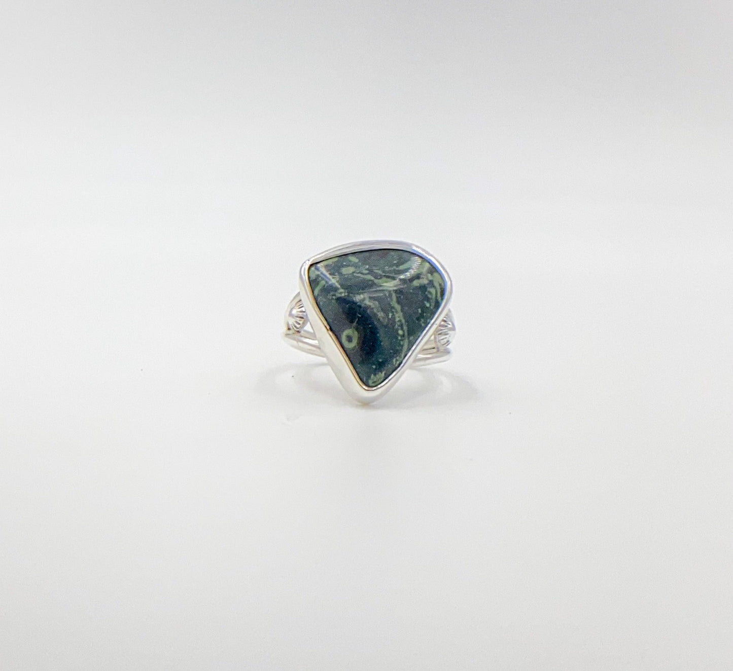 Malachite triangle cabachon mounted an a round profile band. Pieces of ornate granulation surround on the left and right.Split shank band.