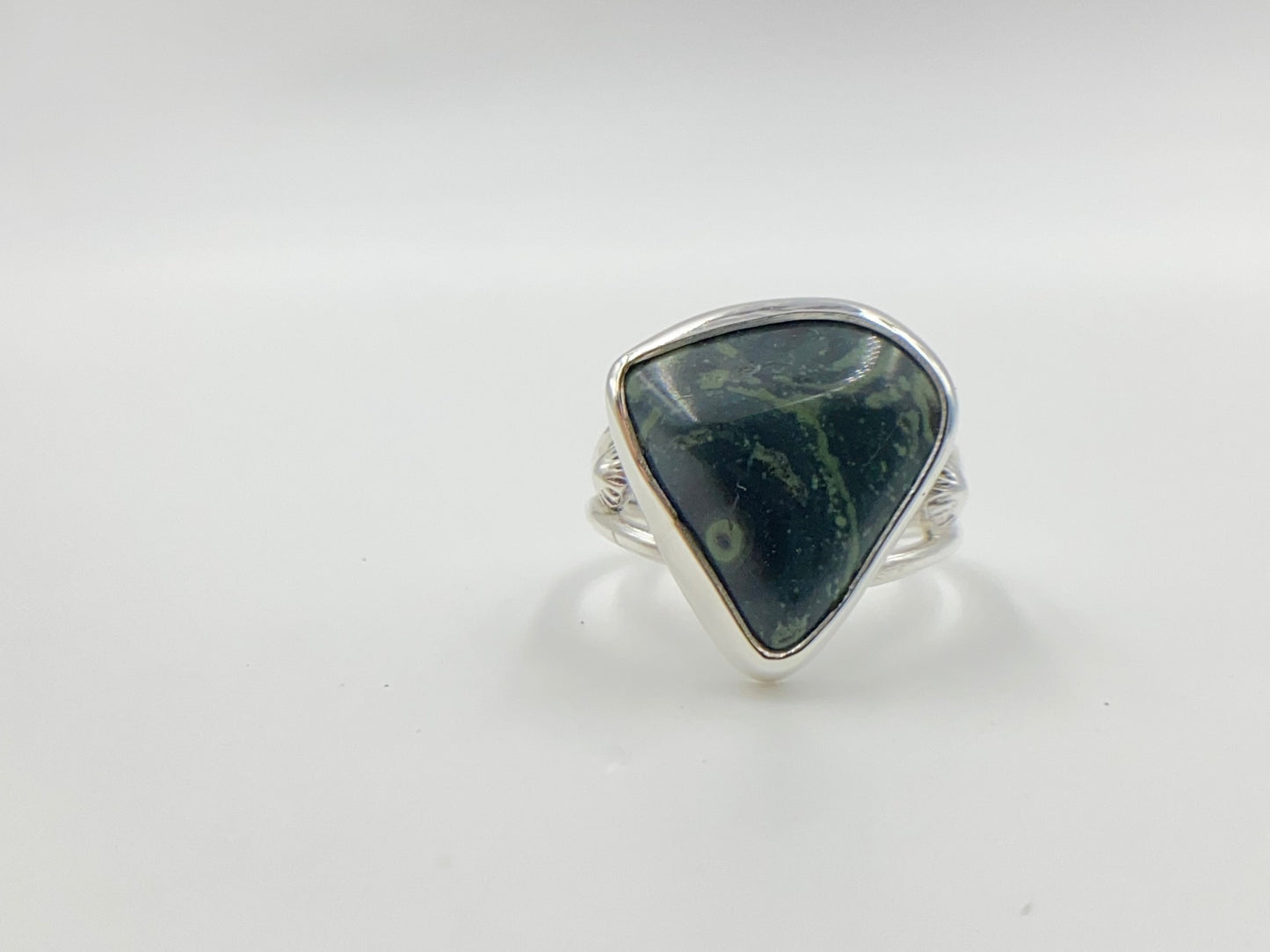 Malachite triangle cabachon mounted an a round profile band. Pieces of ornate granulation surround on the left and right.Split shank band.