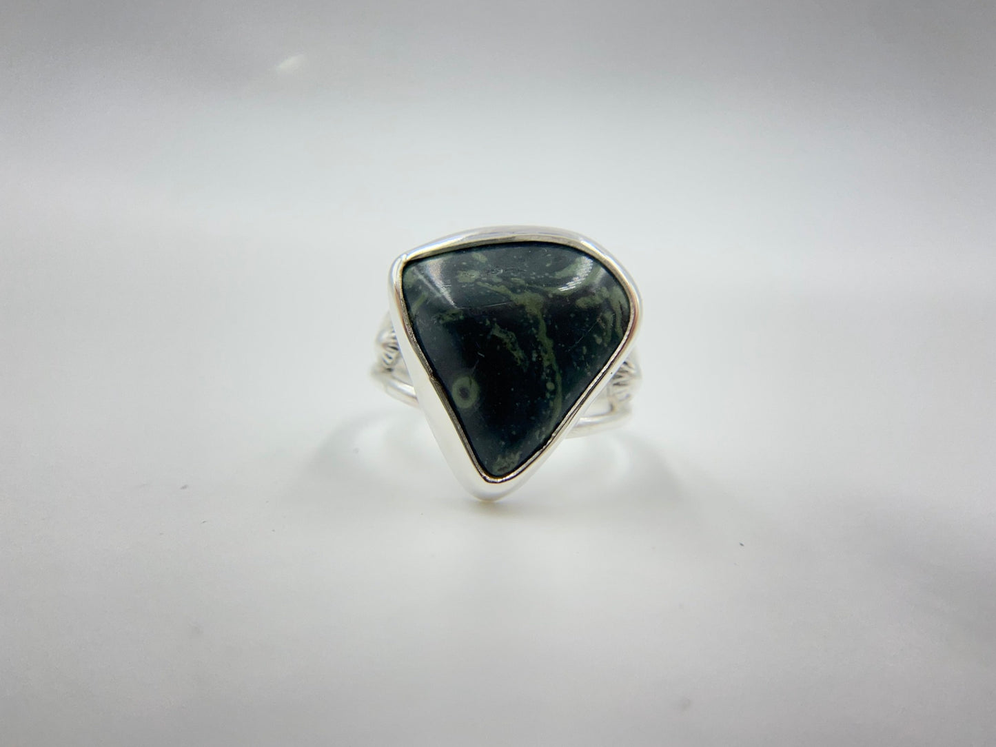 Malachite triangle cabachon mounted an a round profile band. Pieces of ornate granulation surround on the left and right.Split shank band.