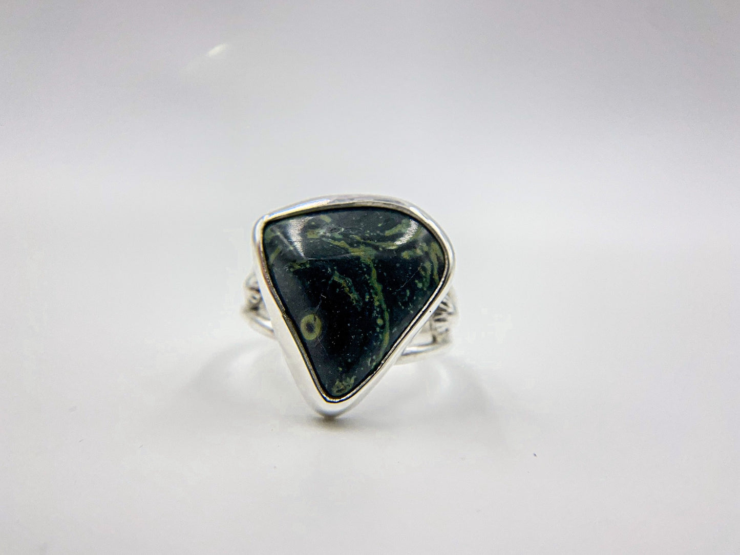 Malachite triangle cabachon mounted an a round profile band. Pieces of ornate granulation surround on the left and right.Split shank band.