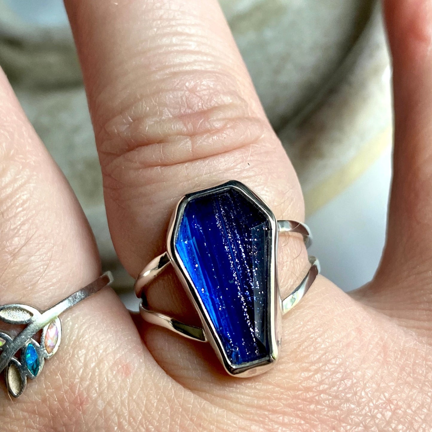 Blue coffin stone threaded with silver and gold through the stone. Split shank size 7 1/4