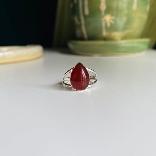 Split shank red pear shaped stone mounted with split shank sterling silver wire.