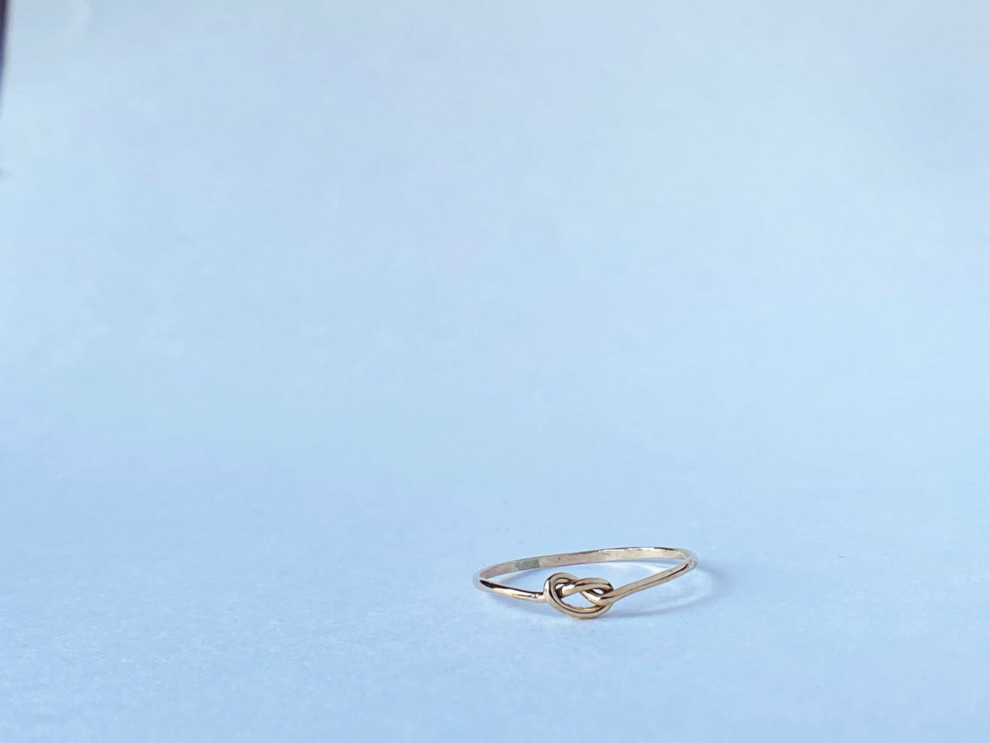 Silver round band twisted to form a small knot dead center of the ring. One continous piece of silver, no solder marks.