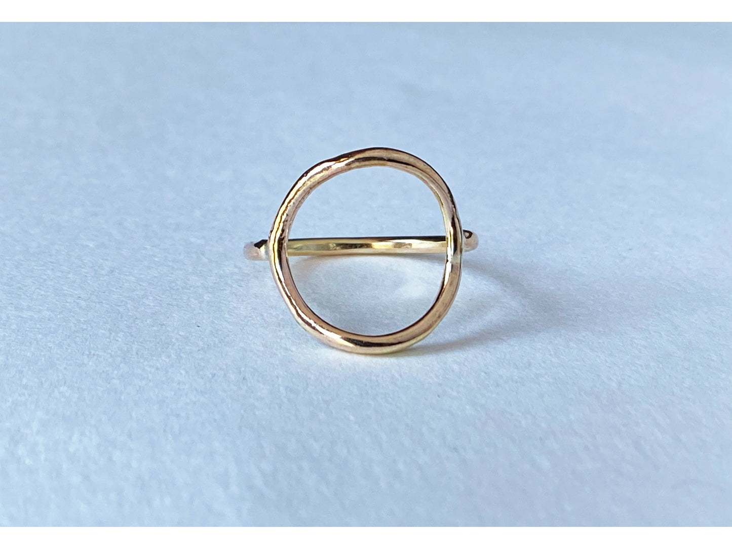 Circle ring in either silver or gold. Band meets the circle on the left and right size, open circle no back.