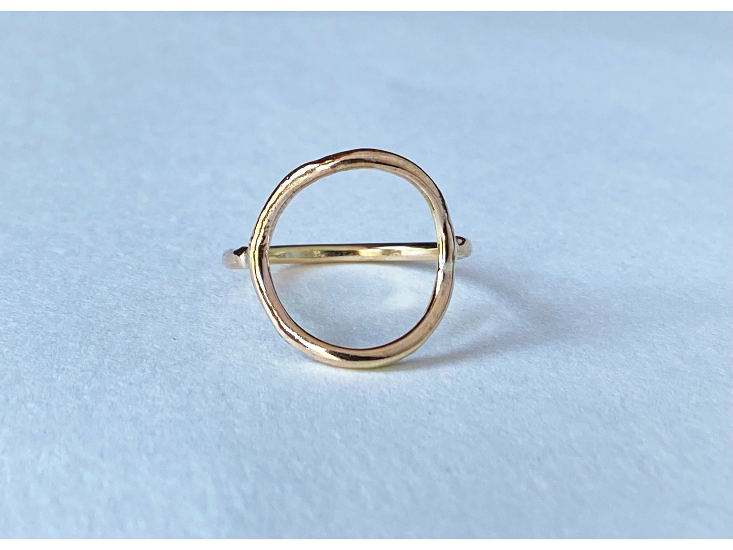Circle ring in either silver or gold. Band meets the circle on the left and right size, open circle no back.
