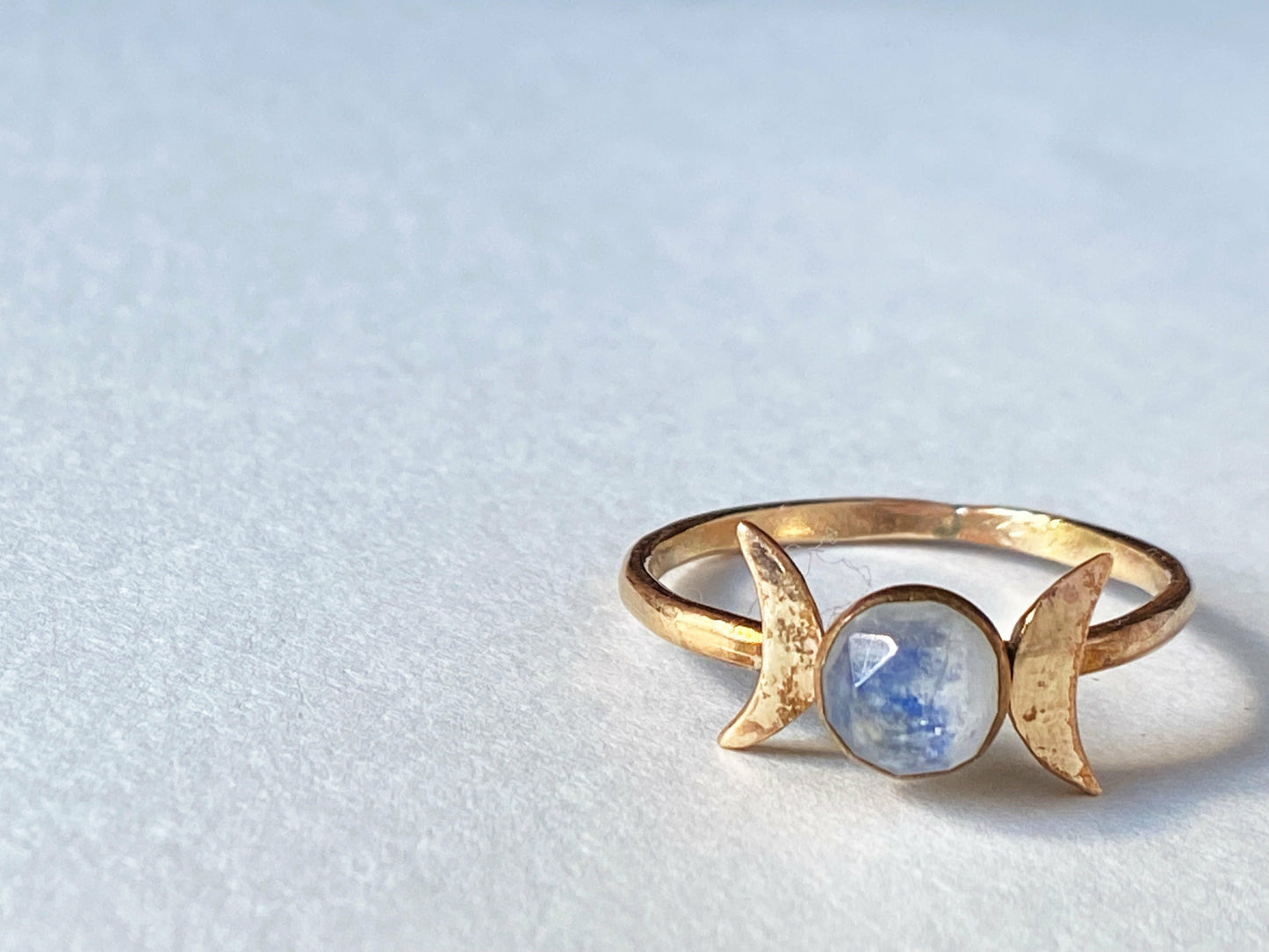 Two moons on the left and right of the stone, moonstone set at focal. Made out of gold filled.