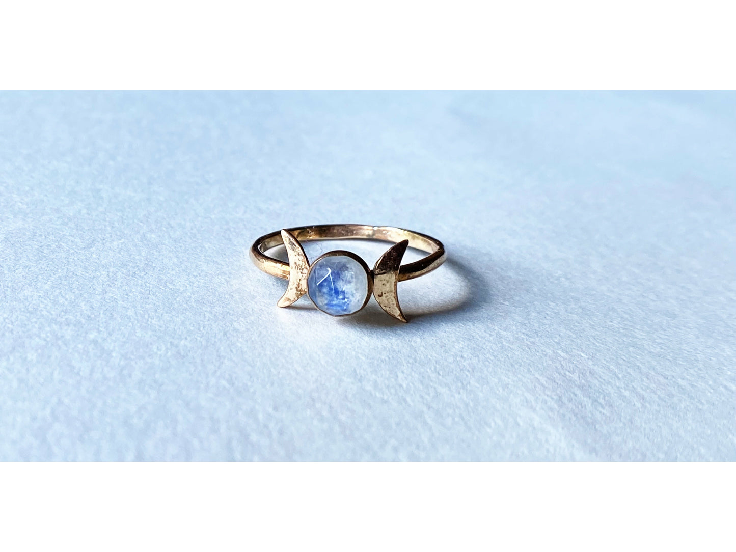 Two moons on the left and right of the stone, moonstone set at focal. Made out of gold filled.