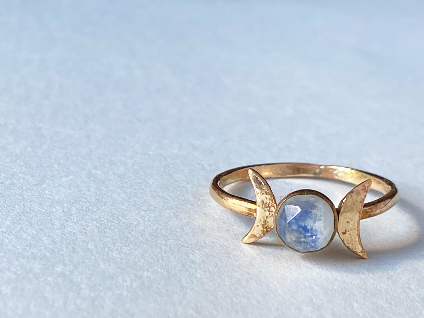 Two moons on the left and right of the stone, moonstone set at focal. Made out of gold filled.