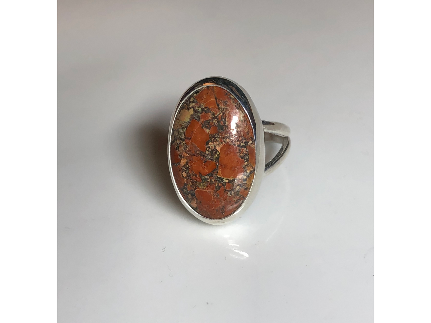 Orange, yellow and oranges grace this oval ring mounted to a simple yet sturdy band