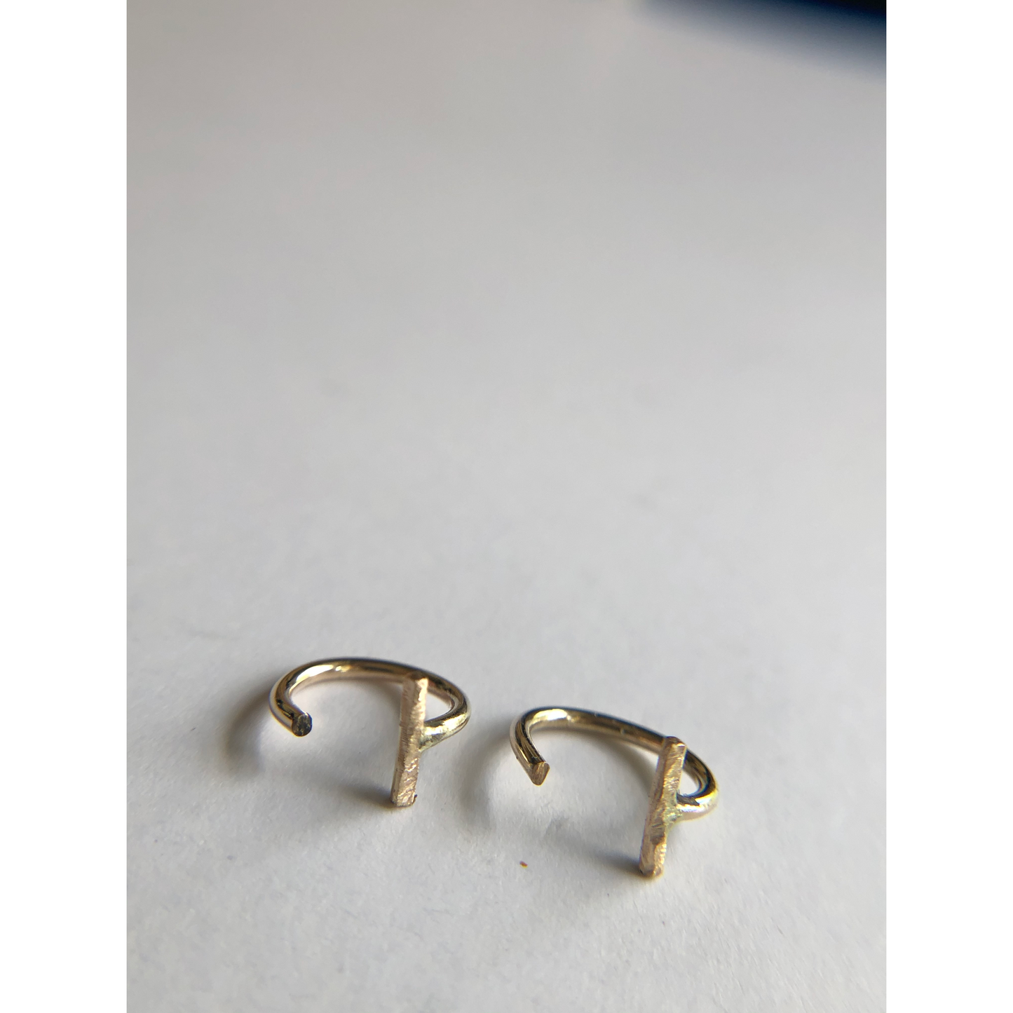 small gold half hoops with bar on one side (ear side) hugs close to ears