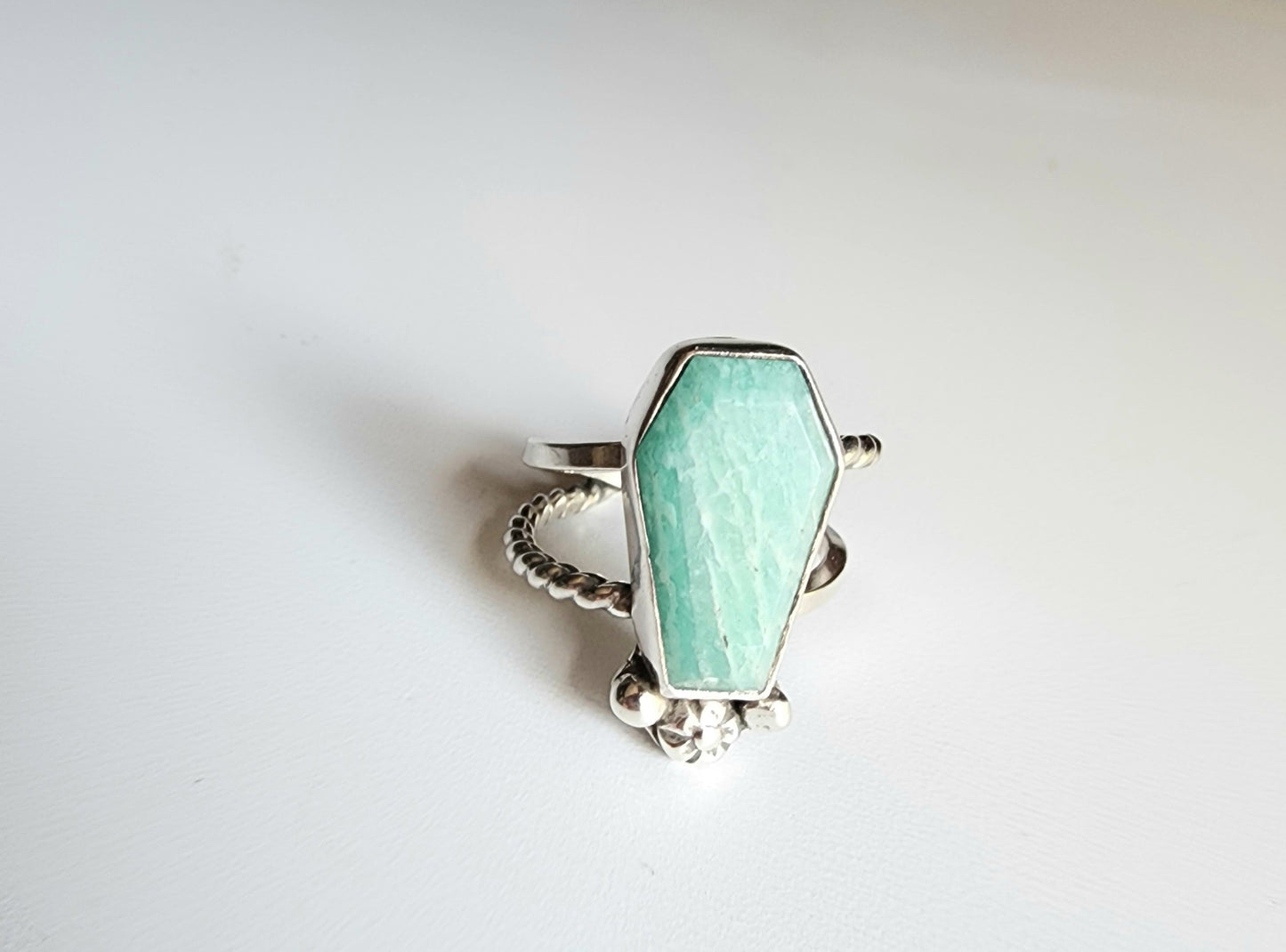 Amazonite coffin stone ring size 7 1/4 split shank with patterned twisted silver on top right and bottom left, square profile on top left and bottom right flower and small granulations on the left and right of small flower at bottom of stone. 