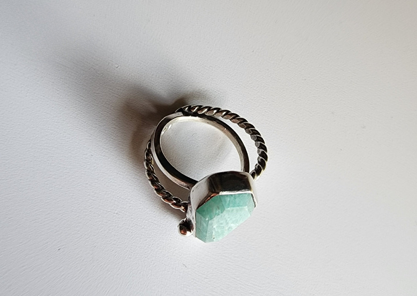 Amazonite coffin stone ring size 7 1/4 split shank with patterned twisted silver on top right and bottom left, square profile on top left and bottom right flower and small granulations on the left and right of small flower at bottom of stone. 