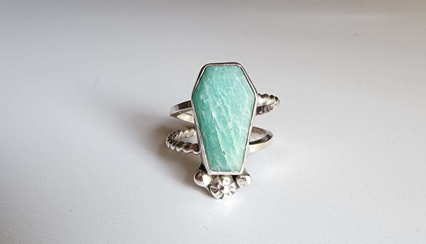 Amazonite coffin stone ring size 7 1/4 split shank with patterned twisted silver on top right and bottom left, square profile on top left and bottom right flower and small granulations on the left and right of small flower at bottom of stone. 
