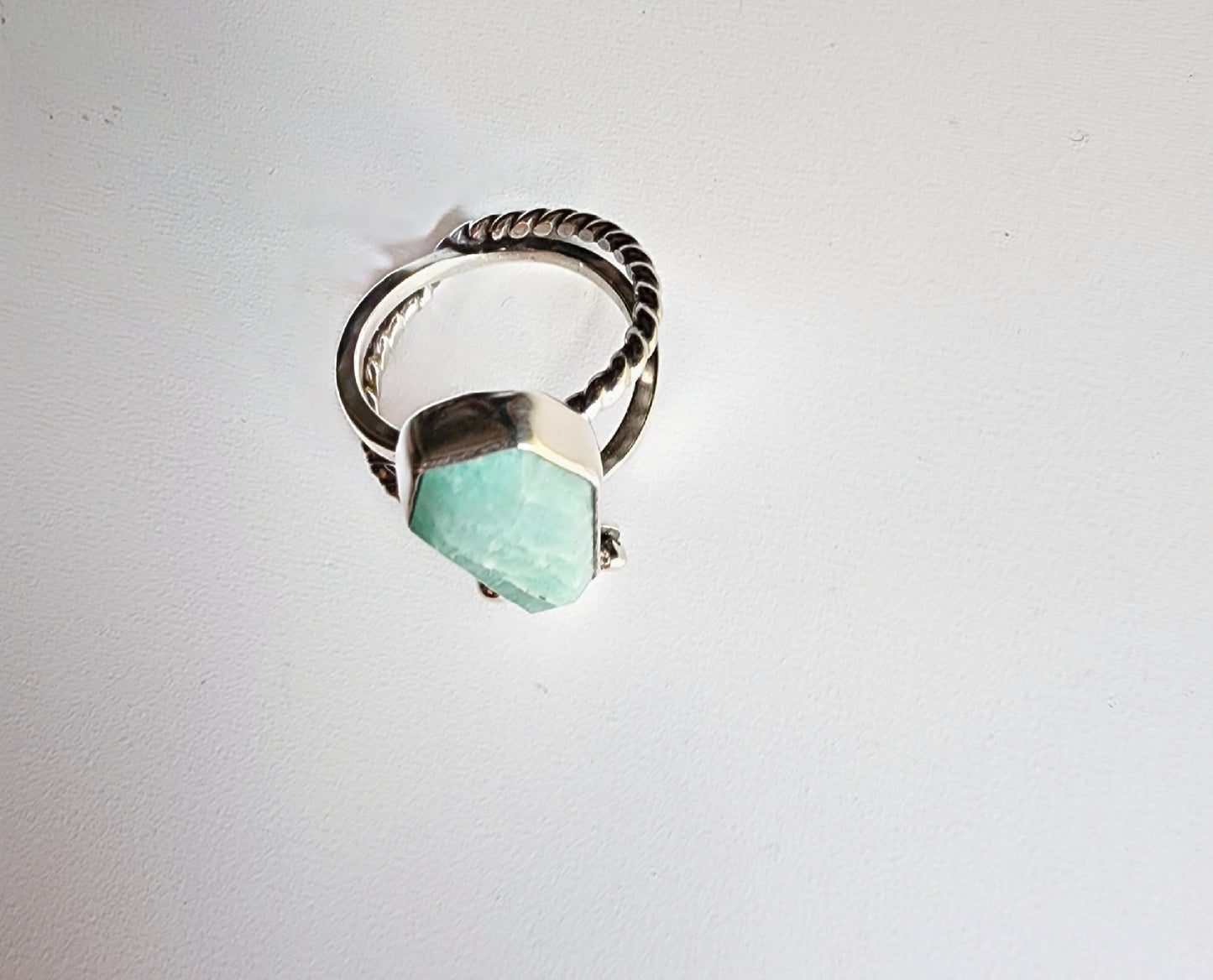 Amazonite coffin stone ring size 7 1/4 split shank with patterned twisted silver on top right and bottom left, square profile on top left and bottom right flower and small granulations on the left and right of small flower at bottom of stone. 