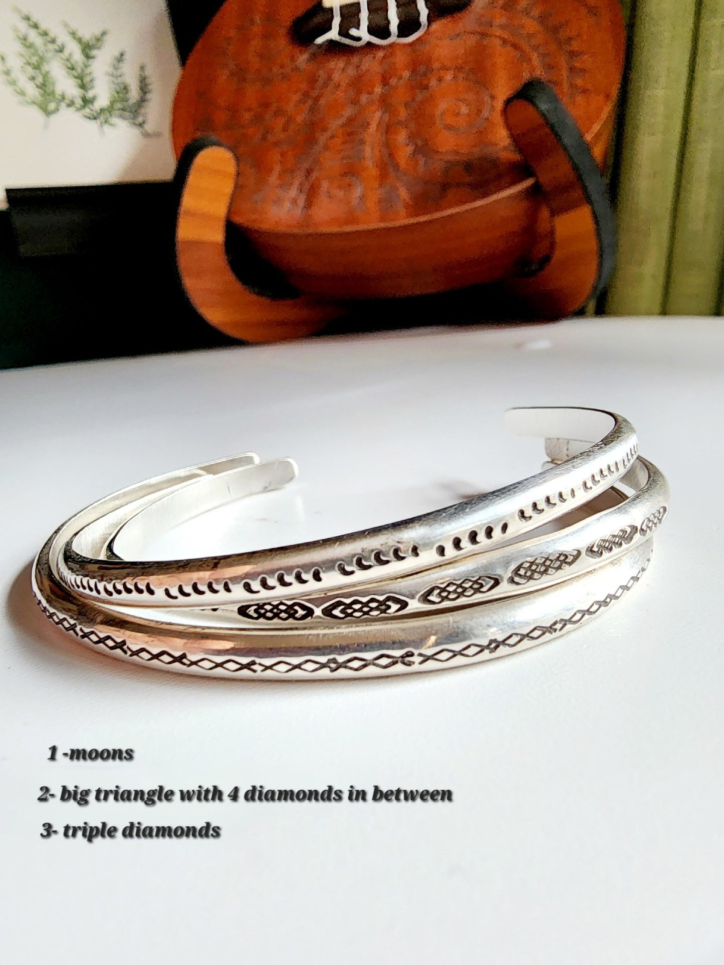 Stamped sterling silver cuff bracelet. Option one is a set of 5 small crescent moons, two is four interlocking triangles stamped continously, option 3 is four diamonds set right next to each other stamped continuously.