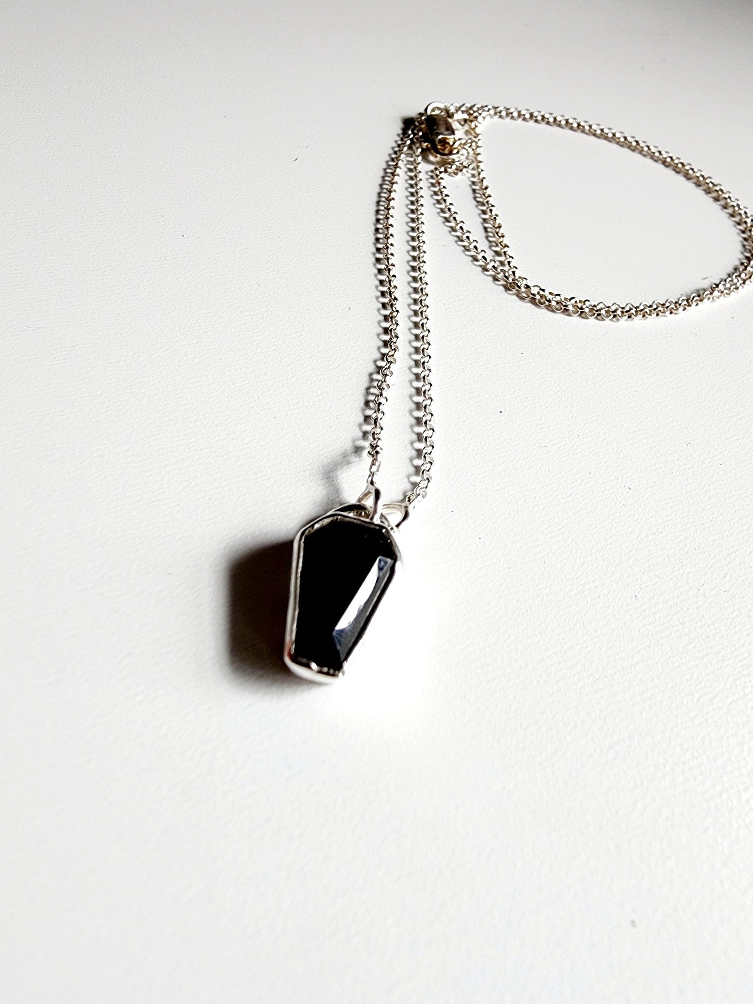 Small onyx black stone in a coffin shape on a simple sterling silver necklace
