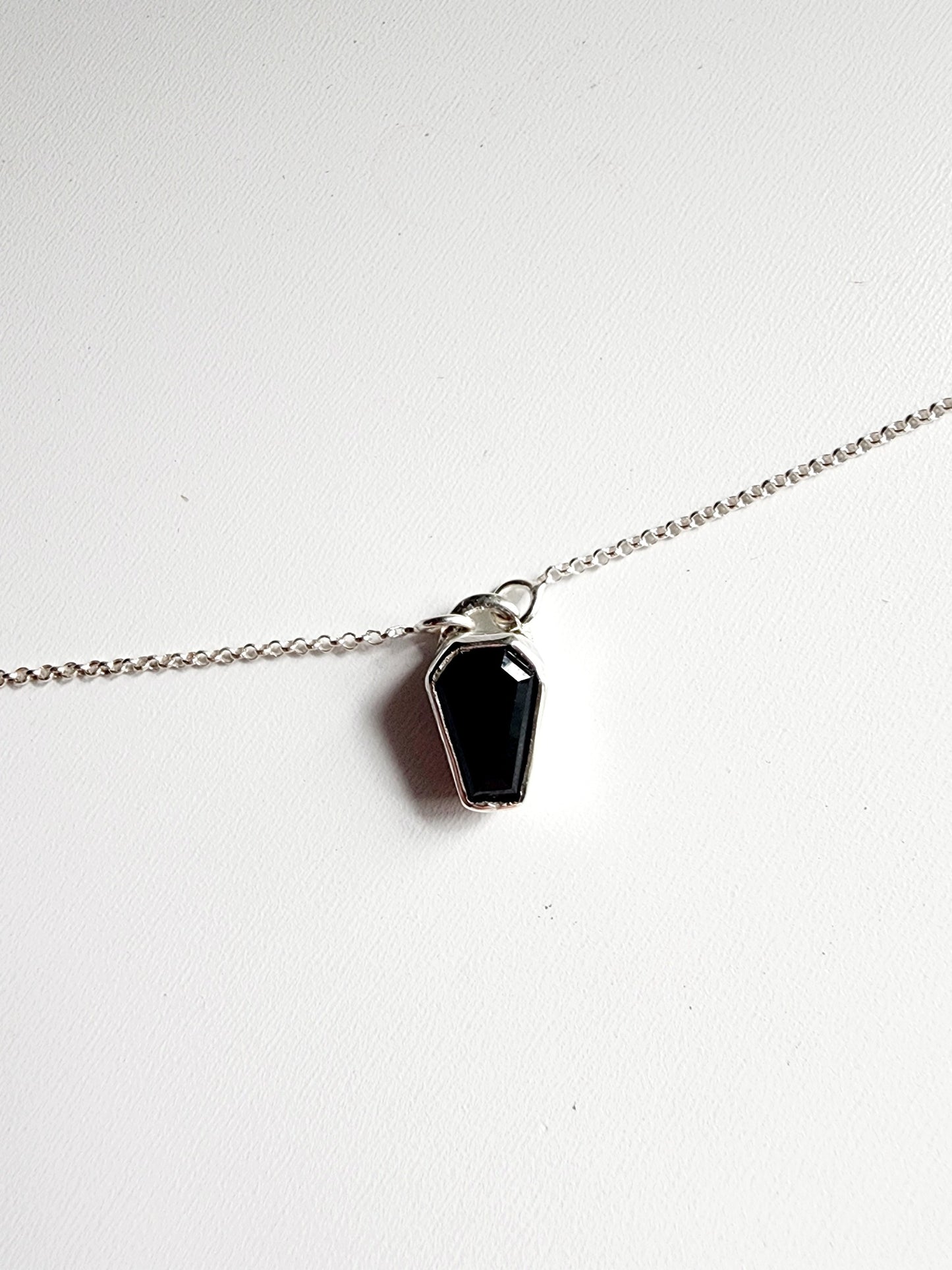 Small onyx black stone in a coffin shape on a simple sterling silver necklace