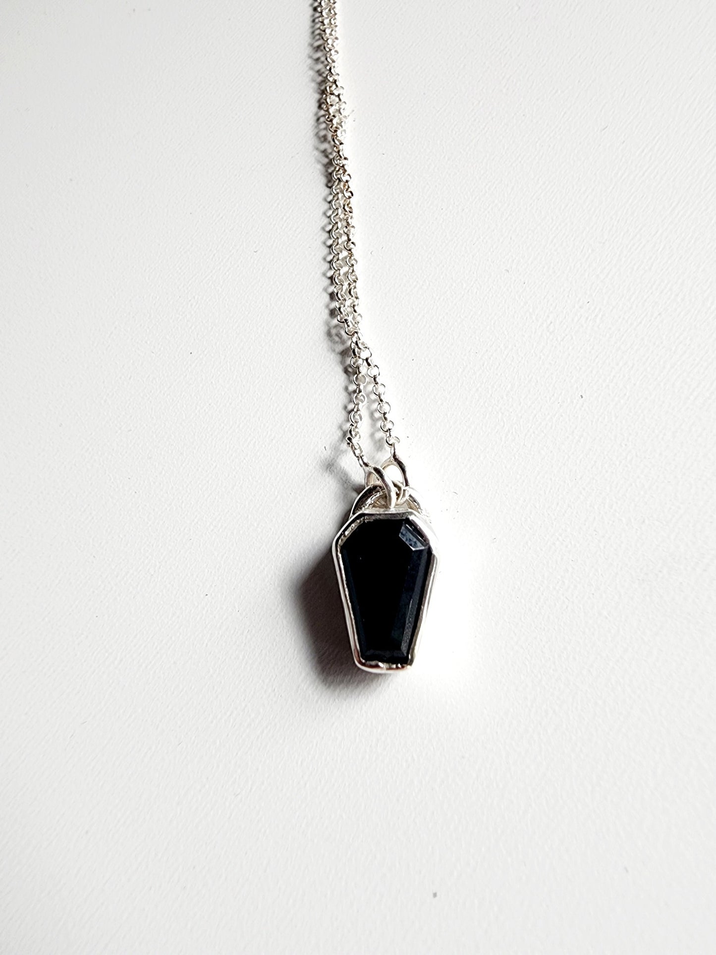 Small onyx black stone in a coffin shape on a simple sterling silver necklace