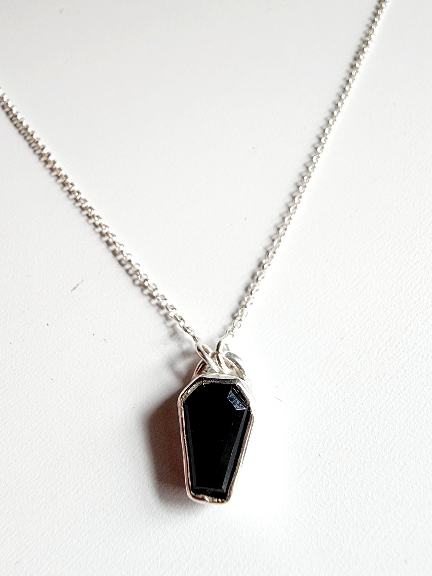 Small onyx black stone in a coffin shape on a simple sterling silver necklace