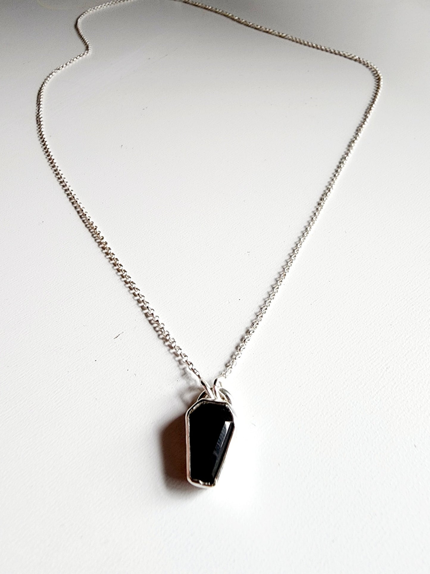 Small onyx black stone in a coffin shape on a simple sterling silver necklace