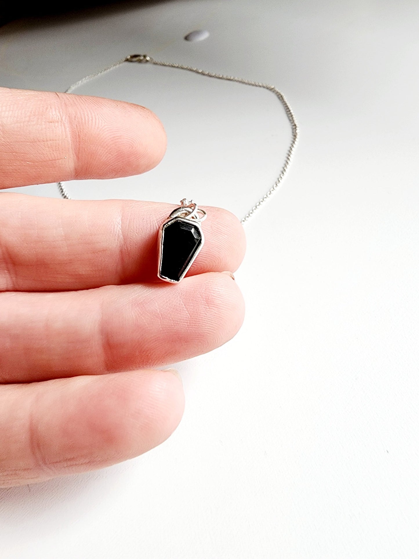 Small onyx black stone in a coffin shape on a simple sterling silver necklace