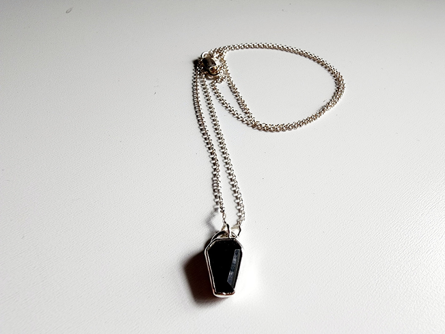 Small onyx black stone in a coffin shape on a simple sterling silver necklace