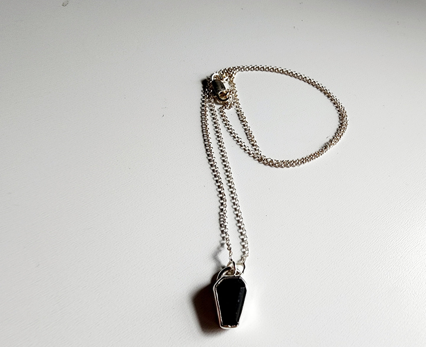 Small onyx black stone in a coffin shape on a simple sterling silver necklace