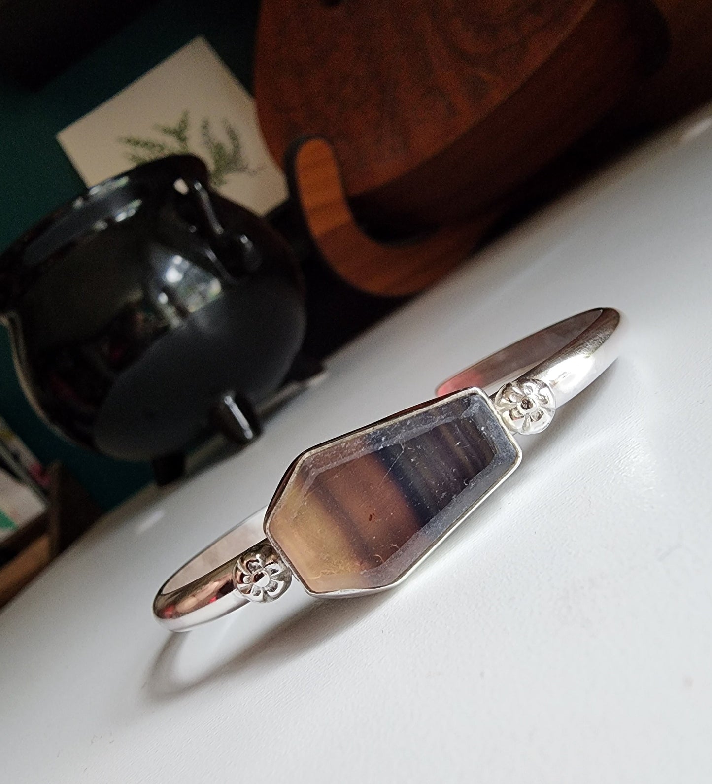 Fluorite coffin stone cuff with small botanical flowers on the left and right mounted on a sterling silver cuff