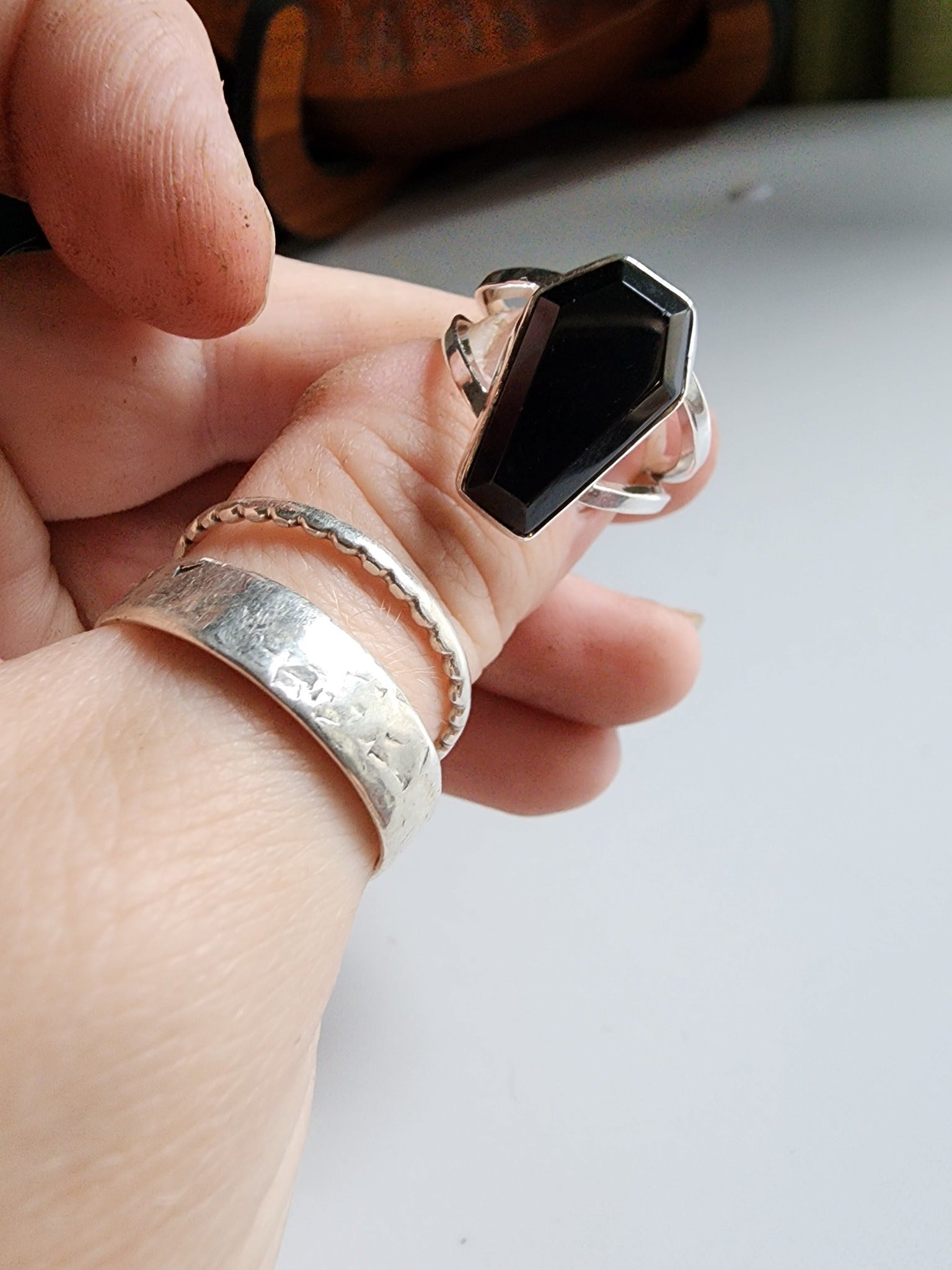 Split shank coffin stone ring with onyx stone. Two silver band extend on the left and right 