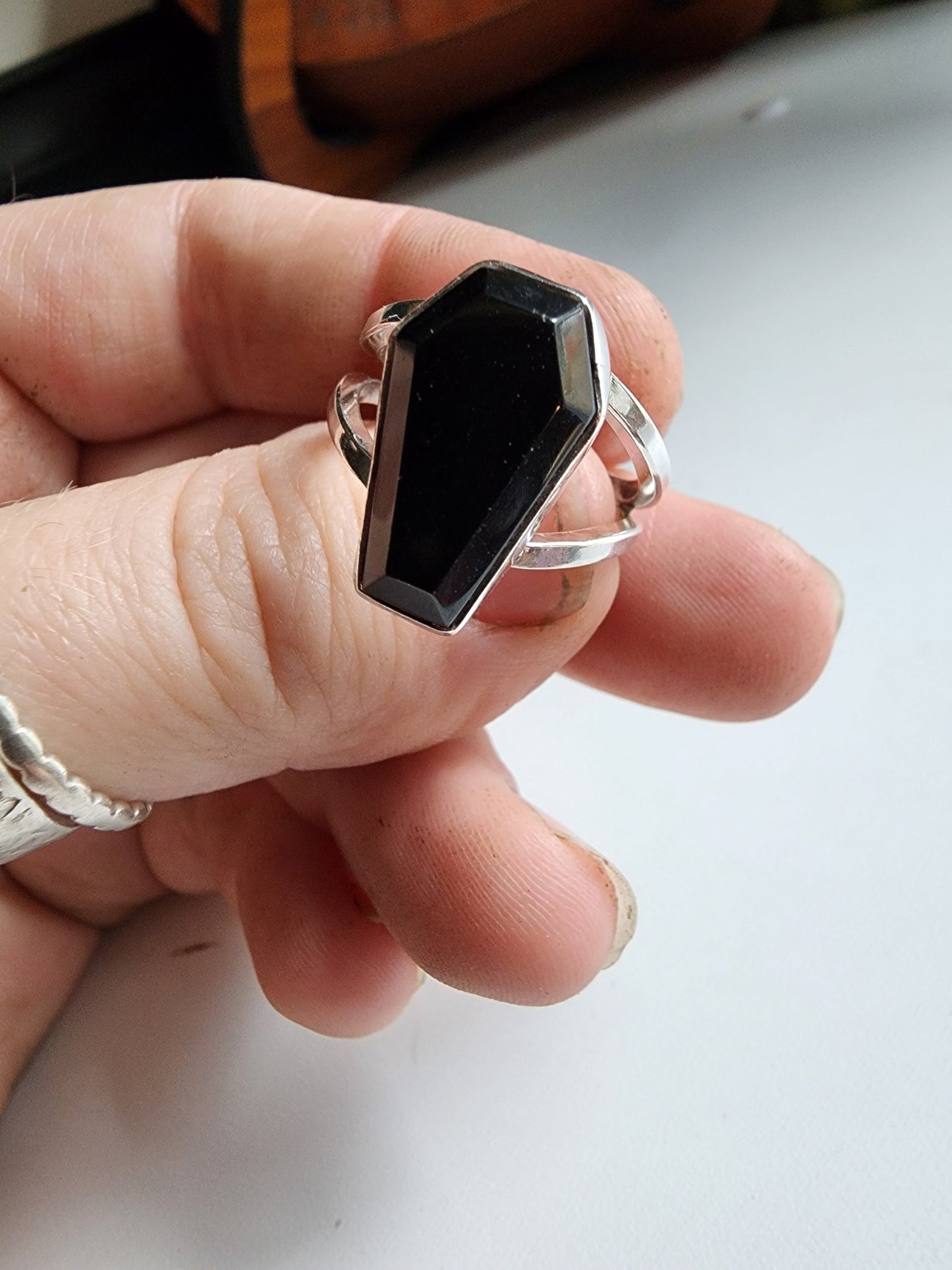 Split shank coffin stone ring with onyx stone. Two silver band extend on the left and right 