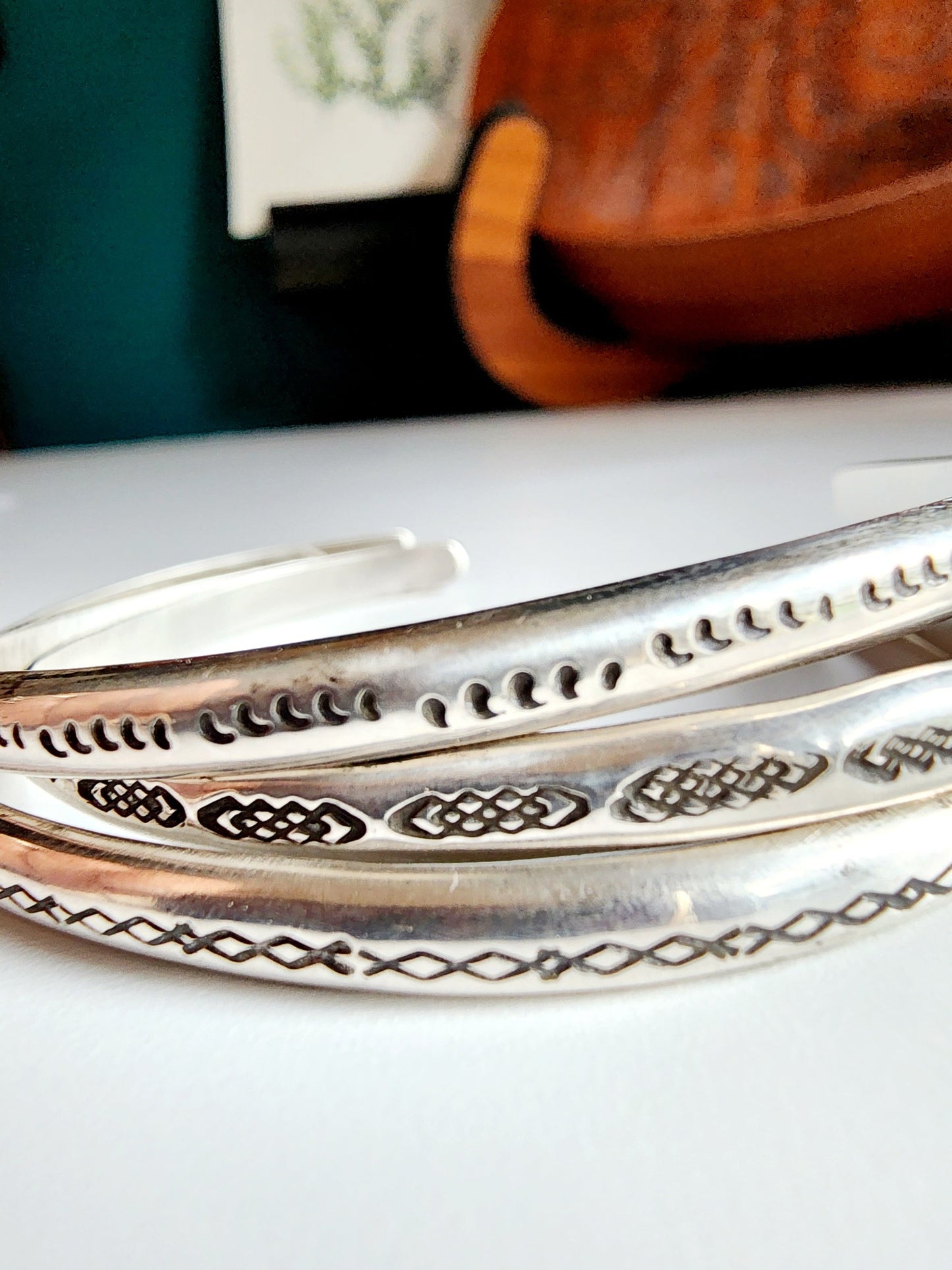 Stamped sterling silver cuff bracelet. Option one is a set of 5 small crescent moons, two is four interlocking triangles stamped continously, option 3 is four diamonds set right next to each other stamped continuously.