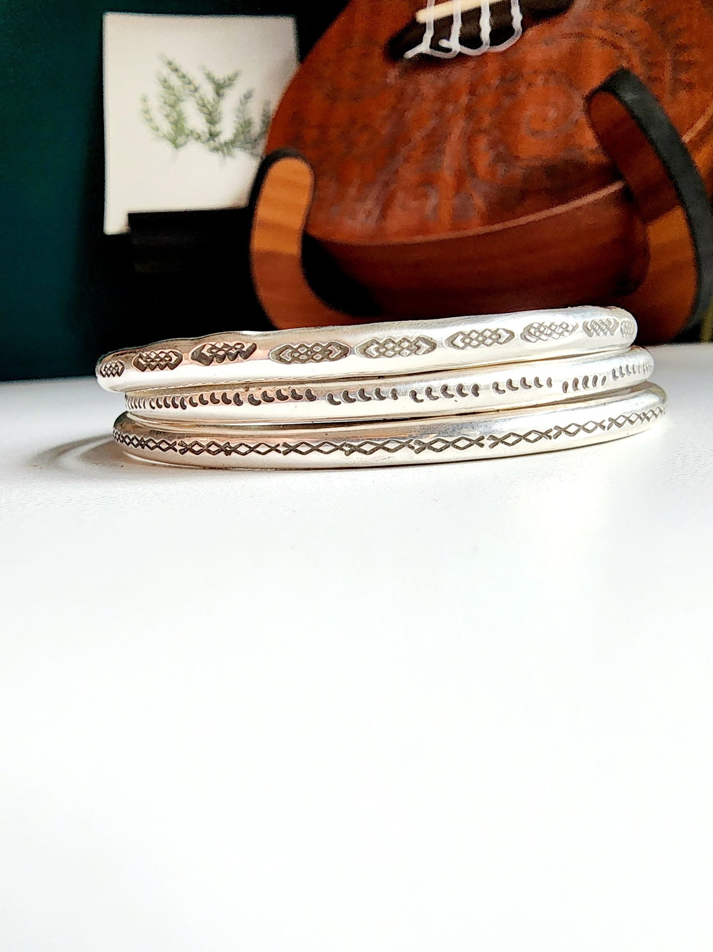 Stamped sterling silver cuff bracelet. Option one is a set of 5 small crescent moons, two is four interlocking triangles stamped continously, option 3 is four diamonds set right next to each other stamped continously.