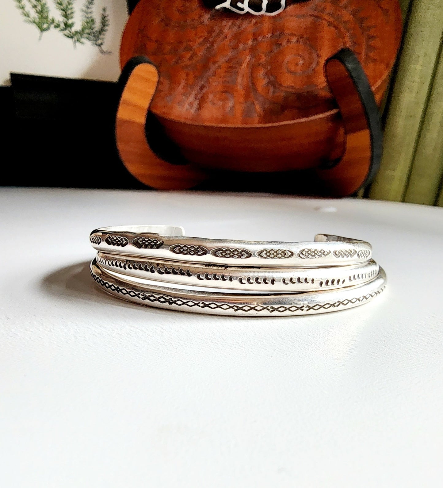 Stamped sterling silver cuff bracelet. Option one is a set of 5 small crescent moons, two is four interlocking triangles stamped continously, option 3 is four diamonds set right next to each other stamped continously.