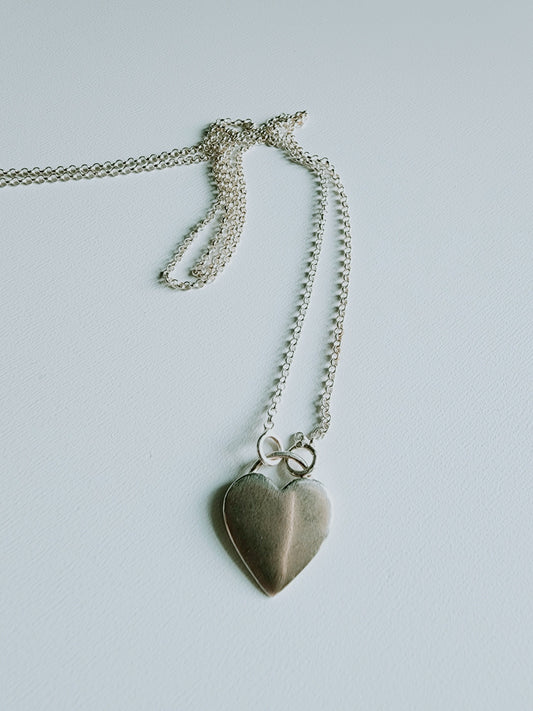 Simple heart necklace mounted on a 18 inch sterling silver necklace, Simple heart rests at the bottom of silver necklace. Minimalist design, pendant is 8mm by 5mm 