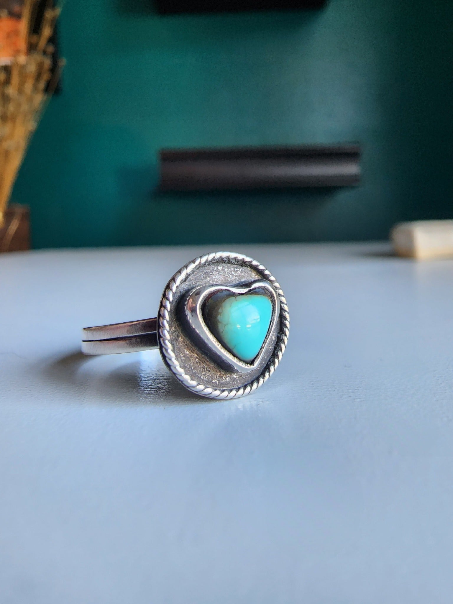 Kingman heart ring with blacked out surround and twisted wire going around. Ring is .925 sterling silver with a double banded shank.