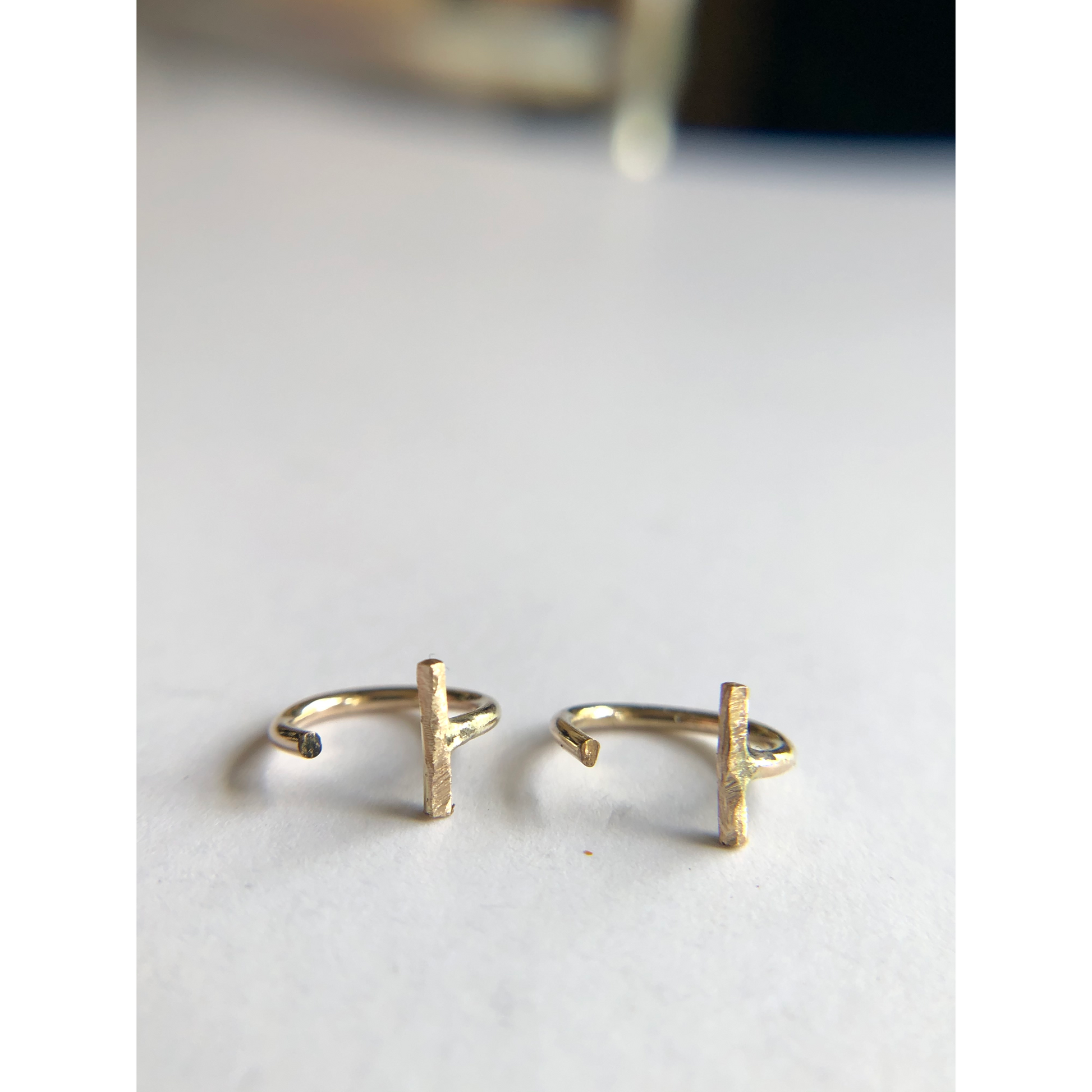 small gold half hoops with bar on one side (ear side) hugs close to ears