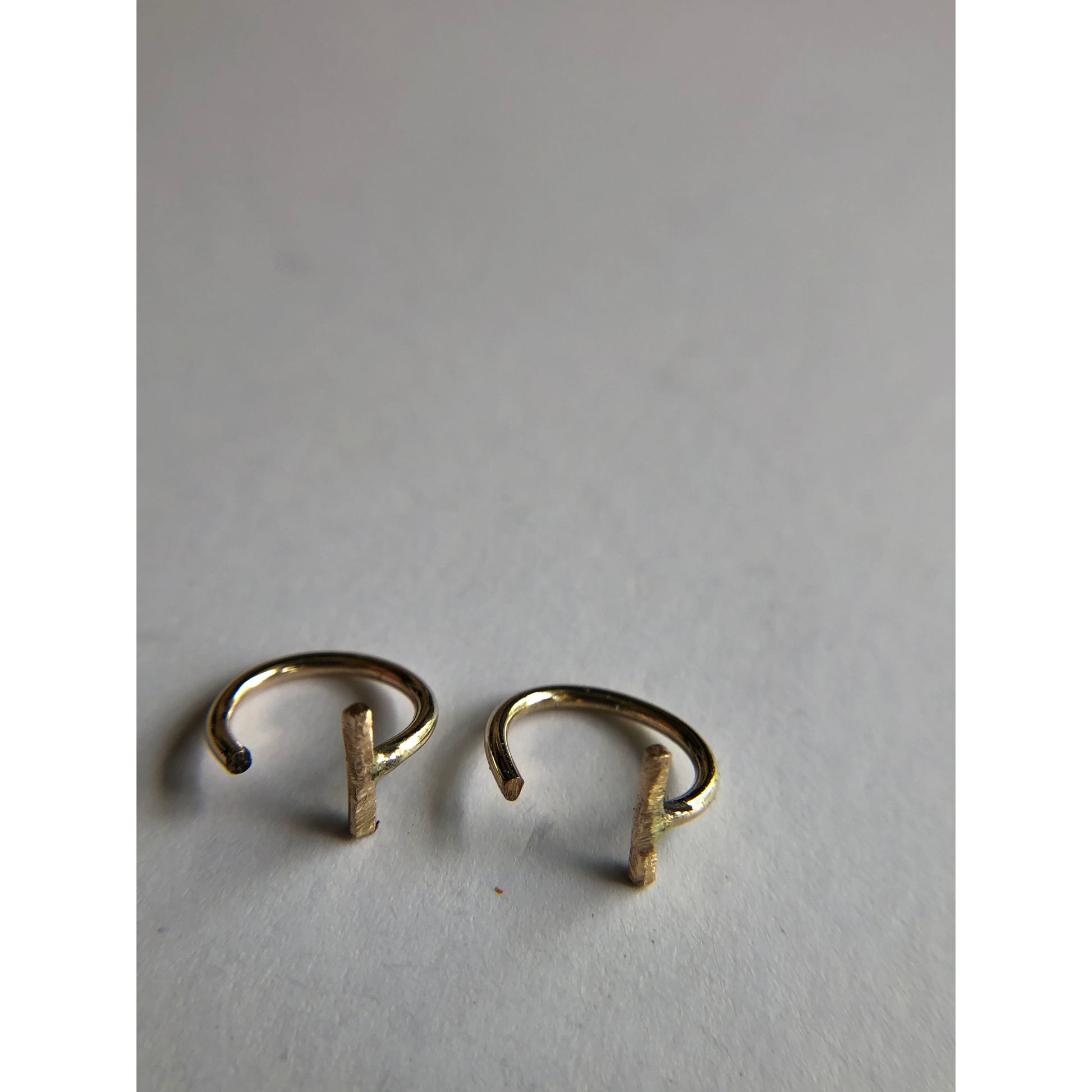 small gold half hoops with bar on one side (ear side) hugs close to ears