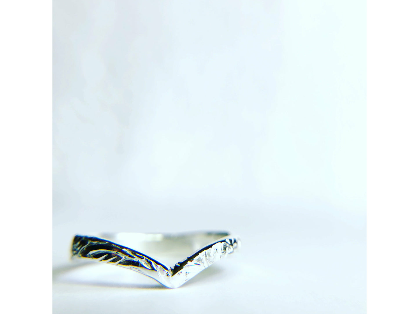 Patterned silver ring with chevron shape. 