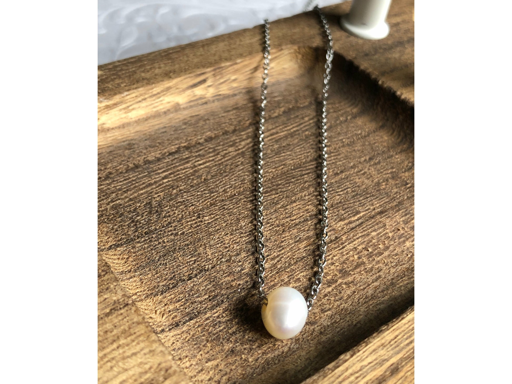 Small simple pearl with the chain of the necklace fed through it