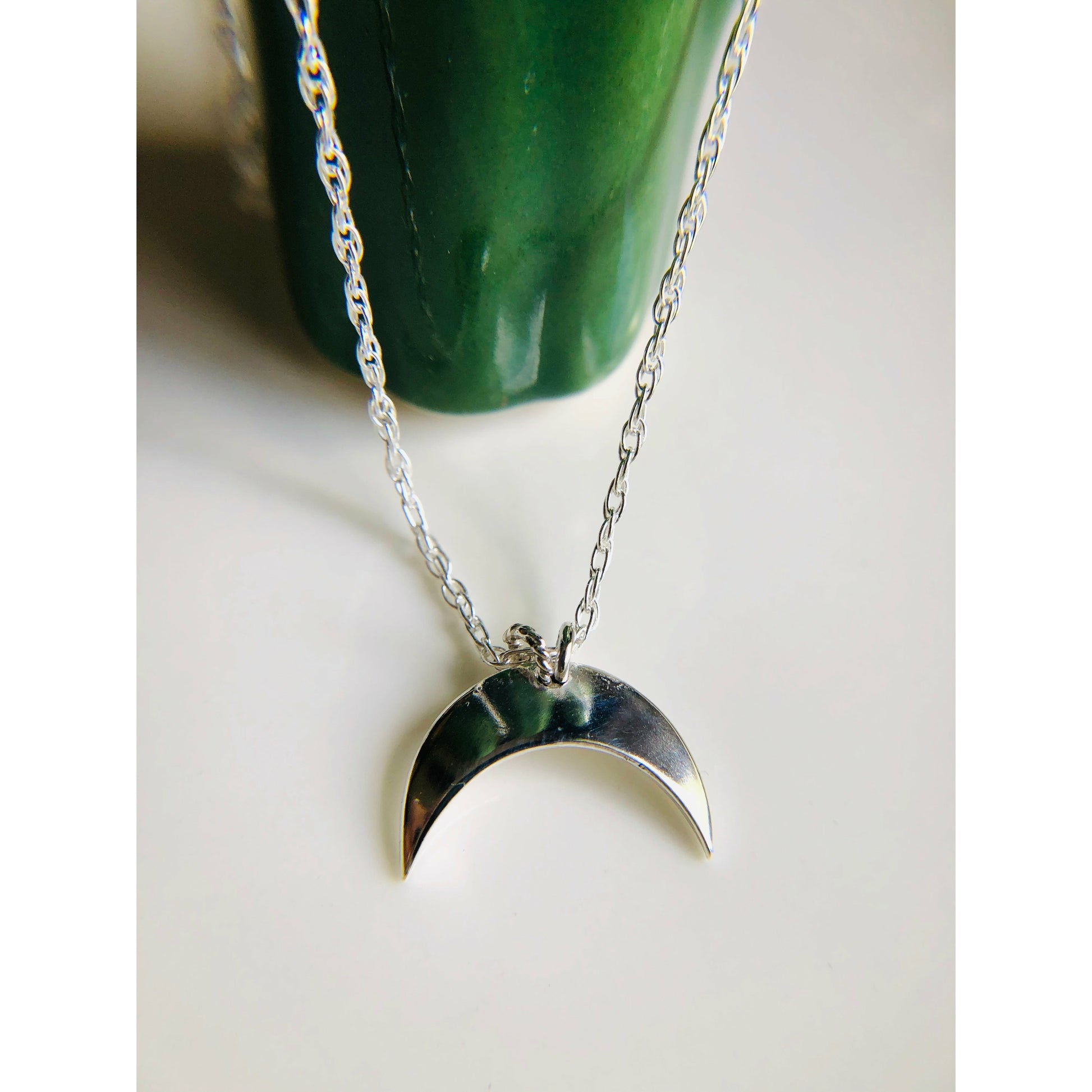 Sterling silver moon shape pointed downward mounted on a stainless steel chain