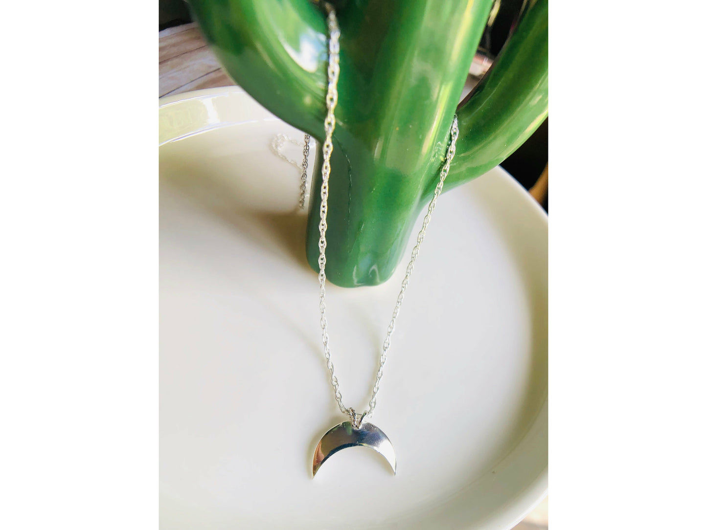 Sterling silver moon shape pointed downward mounted on a stainless steel chain