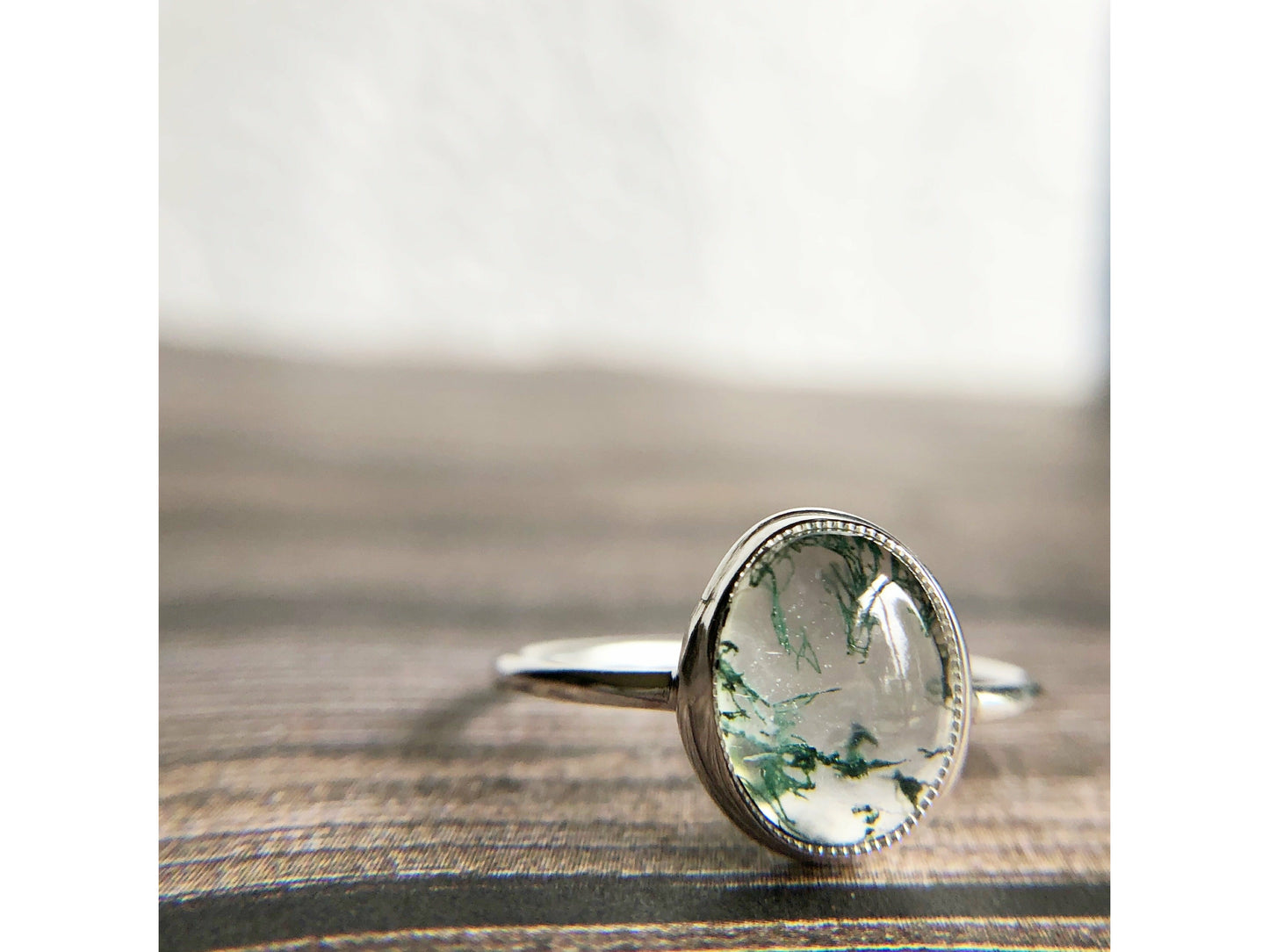 Tiny dots of moss surrounded in quartz, open back bezel with simple silver band