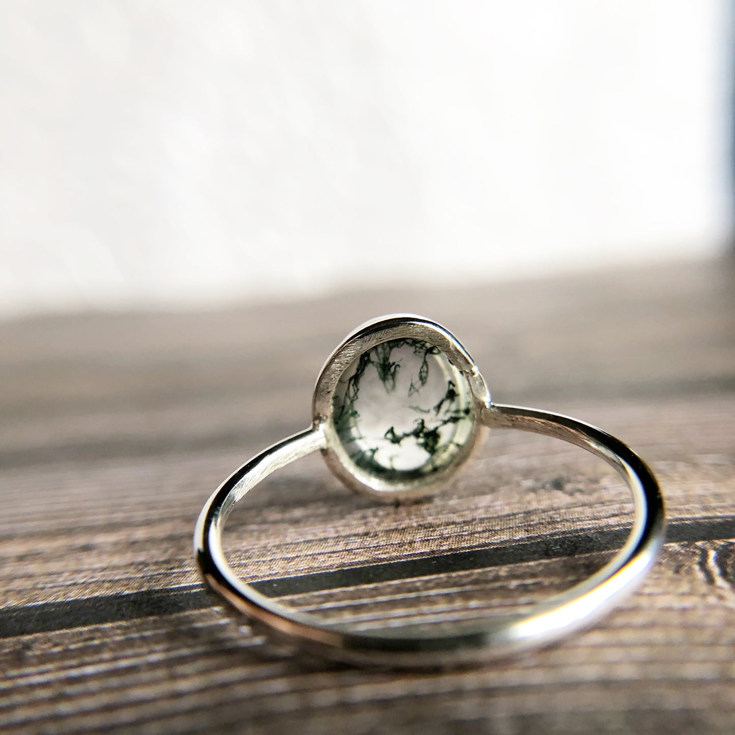 Tiny dots of moss surrounded in quartz, open back bezel with simple silver band