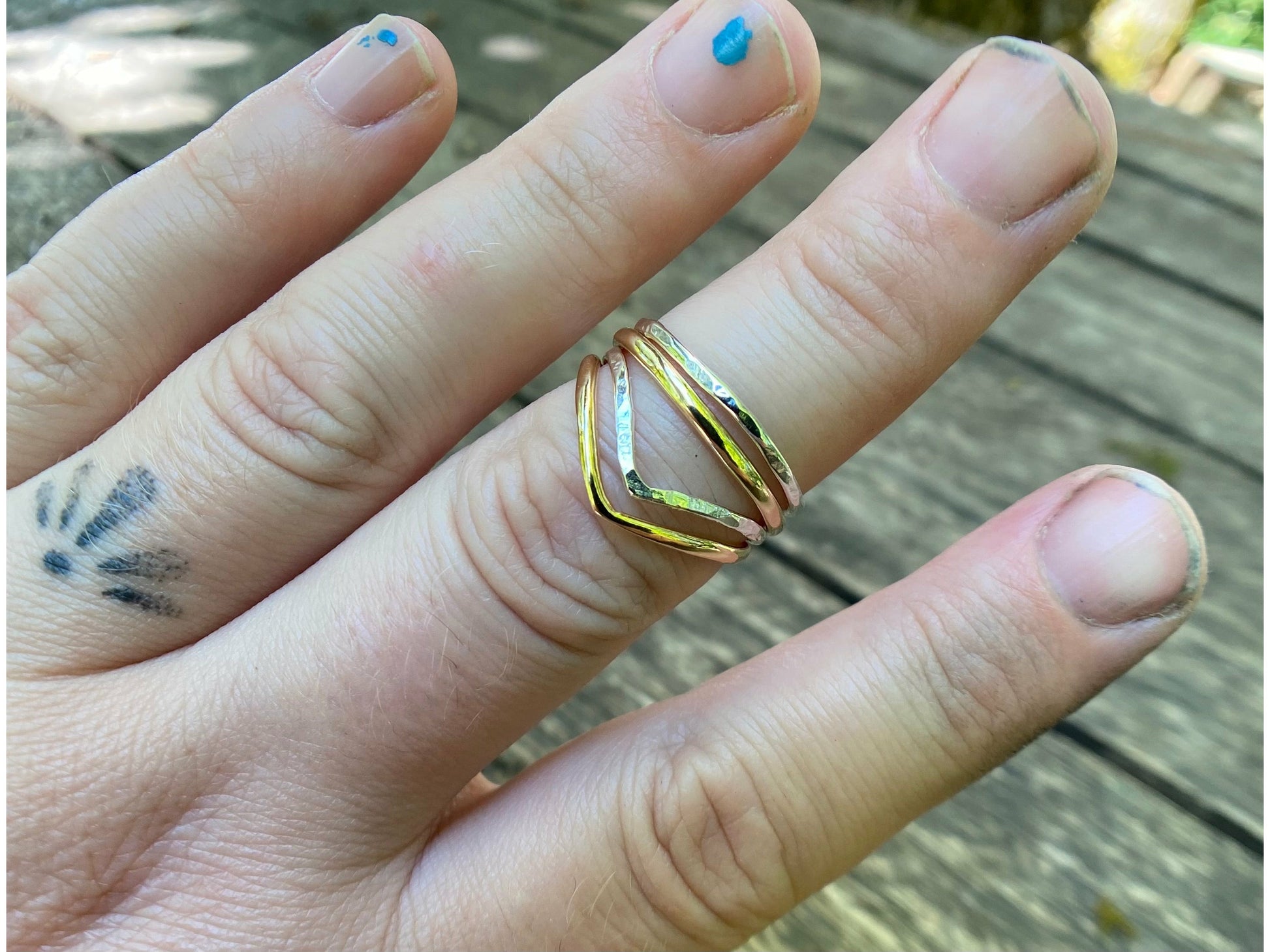 Silver and gold simple rings stacked upon a chevron shaped ring. Perfecting stacking set for a simple forward look.