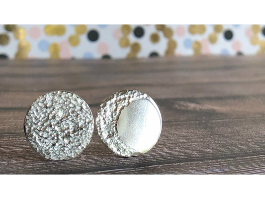 Circle pieces of silver with a crescent moon textured into each earrings. Center post
