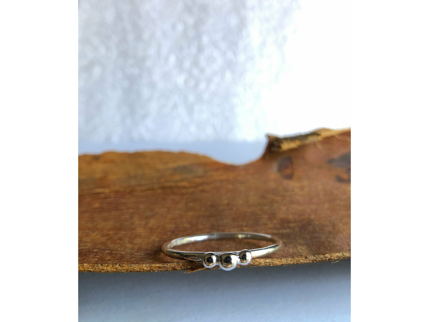 small dots of silver three in total as the focal of this rounded band ring.