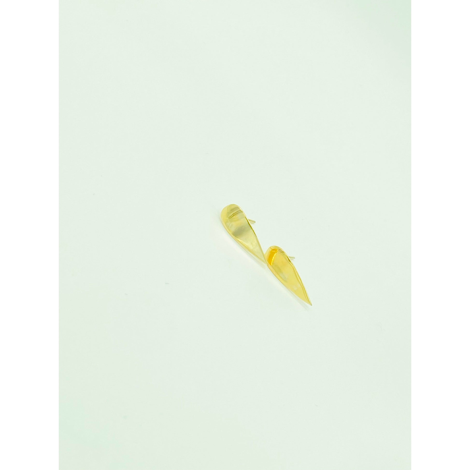 Gold spike earrings with point facing down.