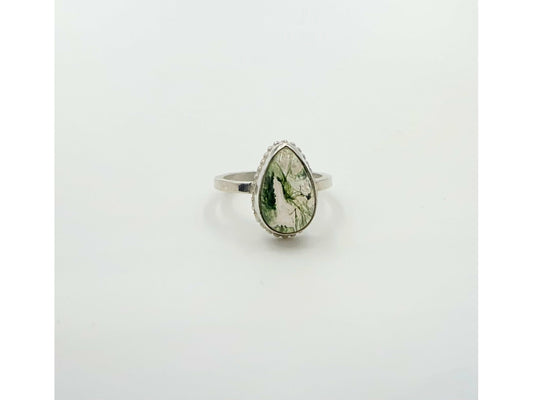 small green moss suspended in quartz, open bezel so light shines through mounted on a rounded simple band.