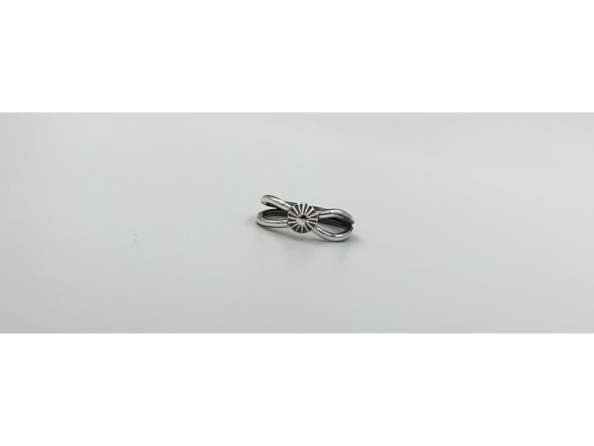 Split shank ring with center focal of a spiral ornated silver pendent. Small and dainty